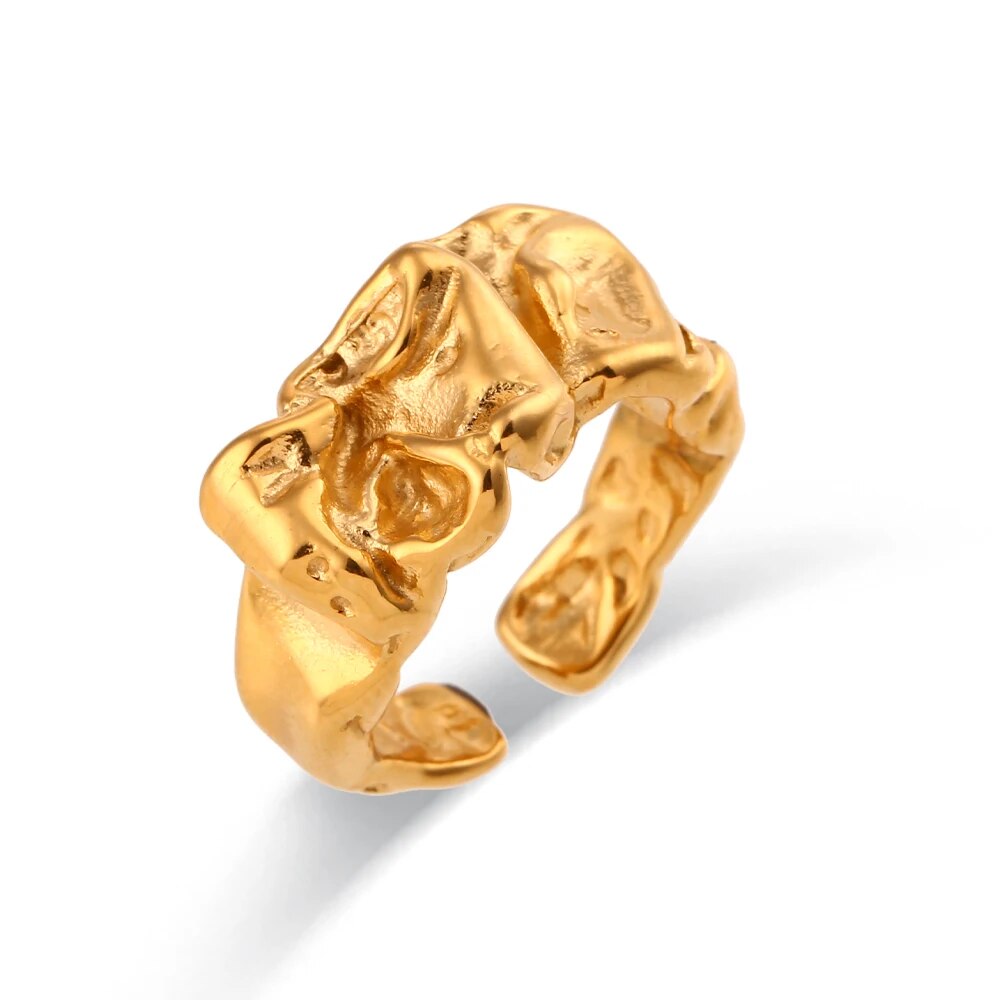 image of gold ring that is abstract with textures shown on a white background