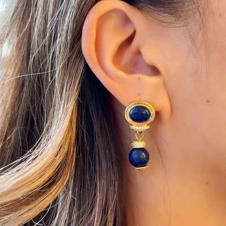 model wearing gold earrings with 2 lapis stone detail and cubic zirconia detail