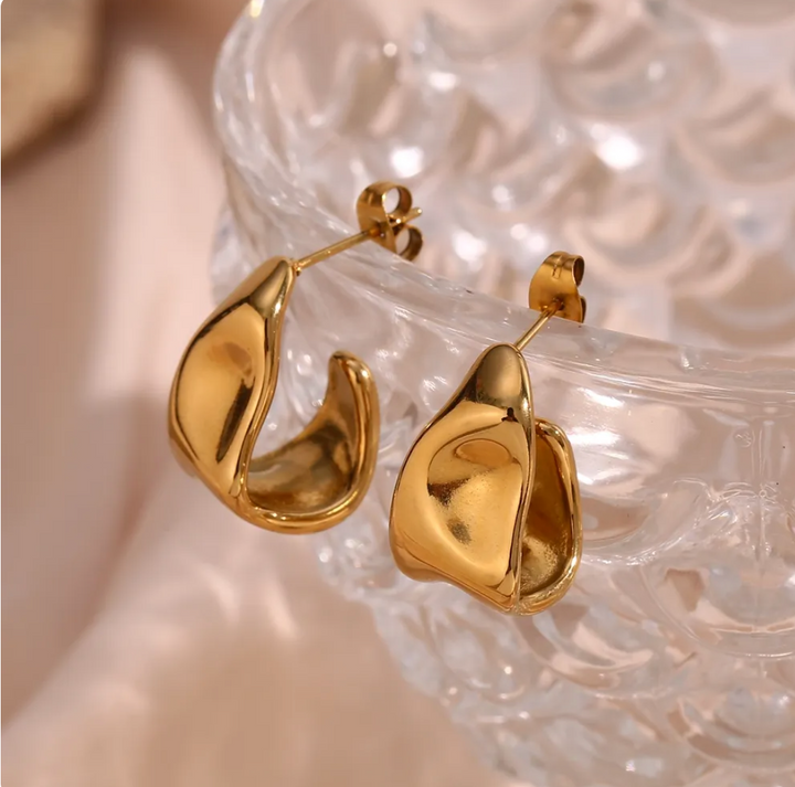 olivia le gold curved hoop earrings with a slight abstract feel