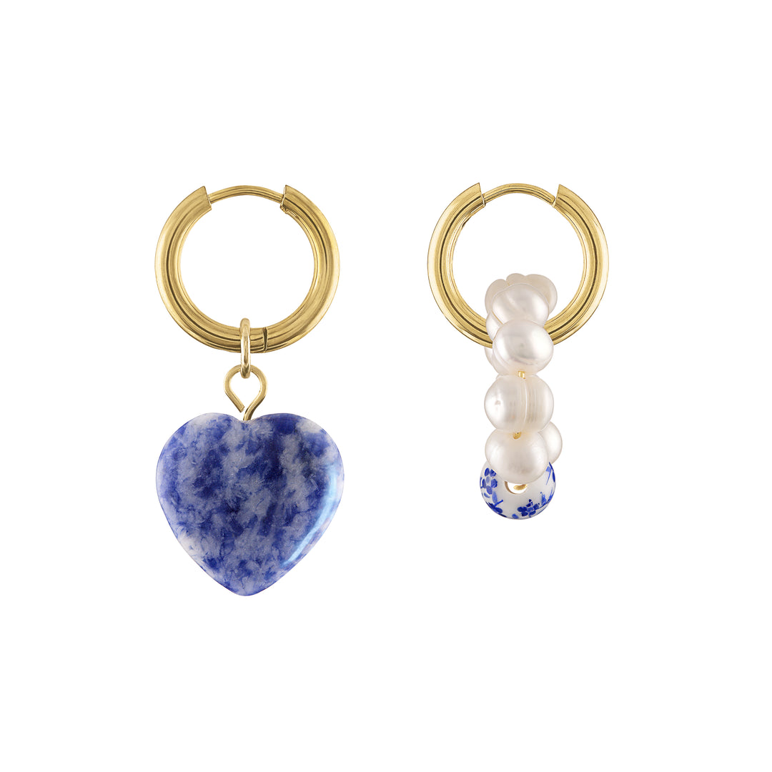 Olivia le hailey blue stone heart charm dangle on a gold hoop earring with a mismatched pair with pearl charms on the other earring