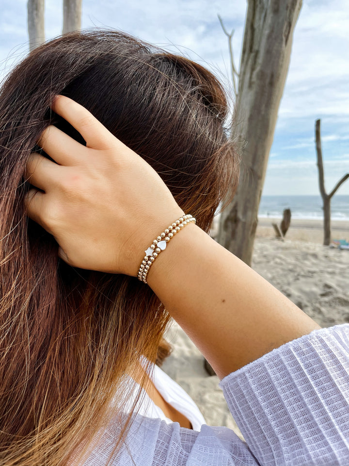 Olivia Le model wearing the Heart Pearl Gold Bracelet stack with Heart Star Gold Bracelet