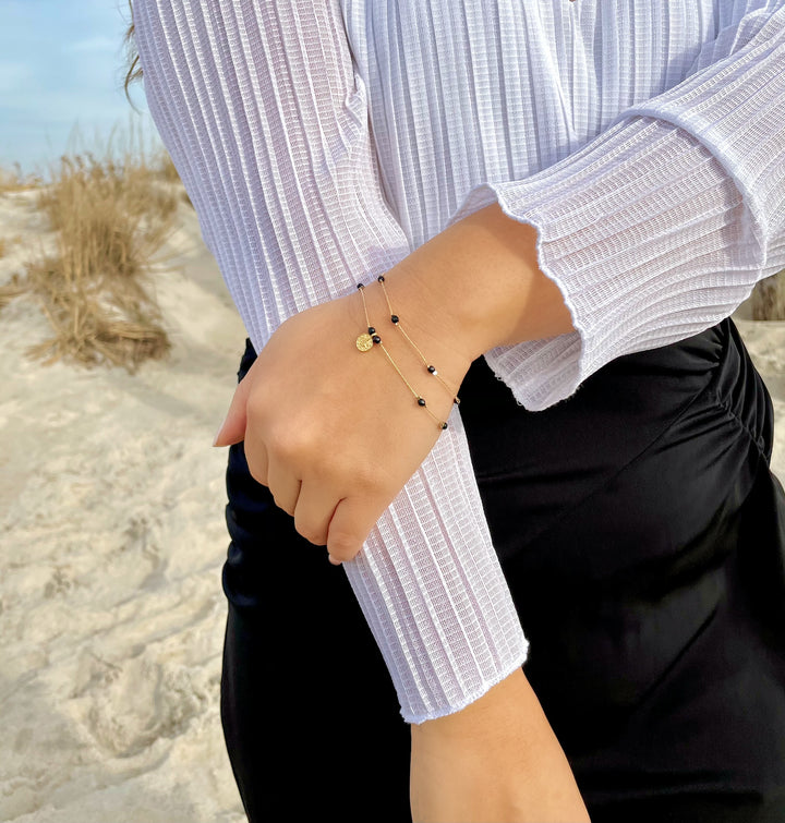 Olivia Le model wearing the Journey Black Agate Beaded Bracelet with Coin Pendant