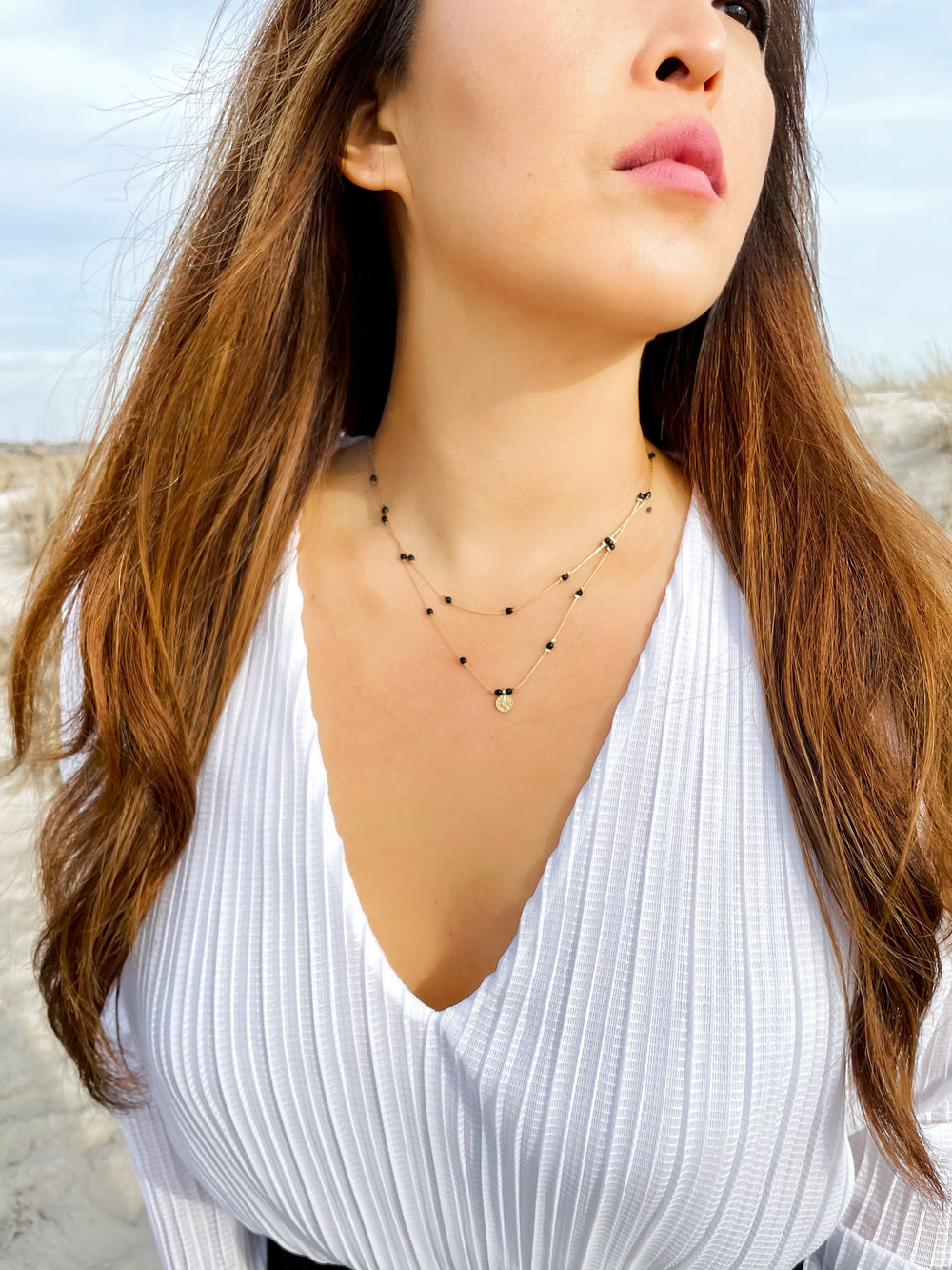 Olivia Le model wearing the Journey Black Agate Beaded Necklace with Coin pendant and white top