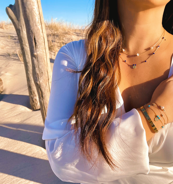 Olivia Le model wearing the Journey Turquoise Magnesite Beaded Bracelet with Coin pendant stack with the Journey collection bracelets and necklaces