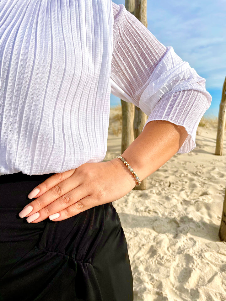 Olivia Le model wearing the Labradorite Power Gem Bubble Bracelet with white top