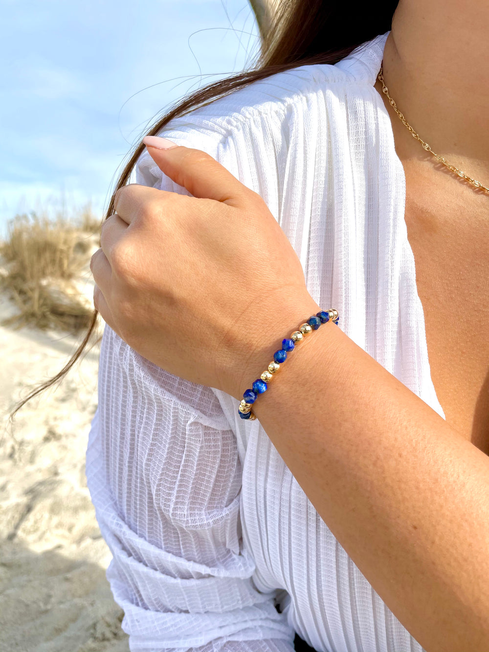 Olivia Le model at the beach wearing the Lapis Lazuli Power Gem Gold Bubble Beaded Bracelet
