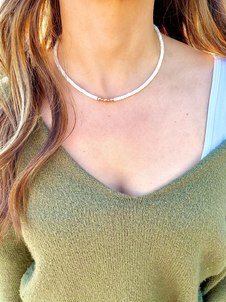 Olivia Le model wearing leilani mother of pearl necklace showcasing the pearl details and wearing a v neck sweater