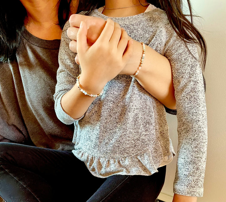 mommy and me wearing matching gemstone beaded bracelets posing together