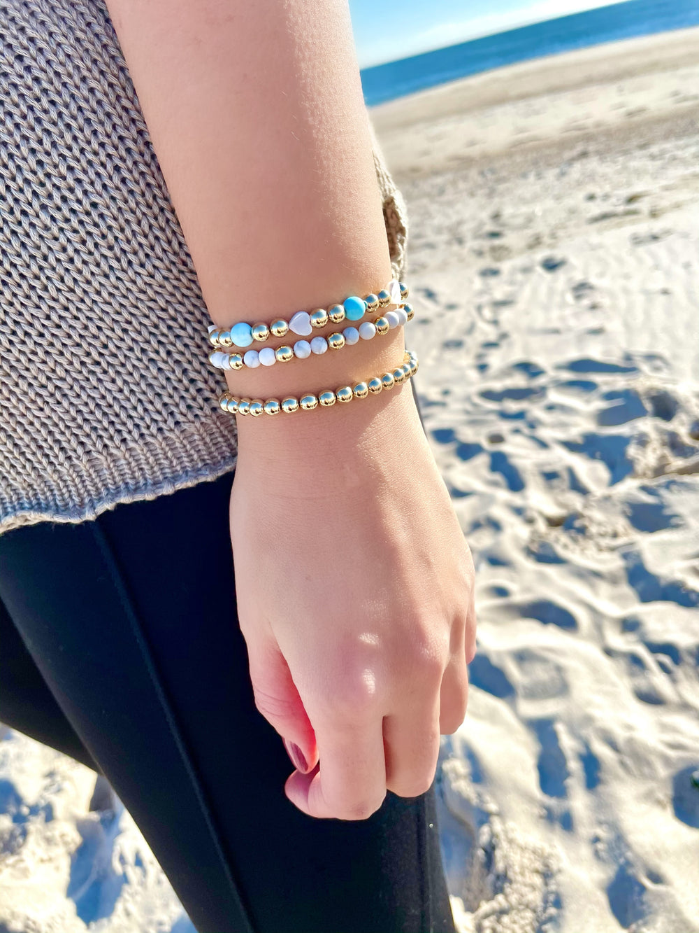 Olivia Le model at the beach wearing the Santorini Dreams Pearl Gold Bracelet