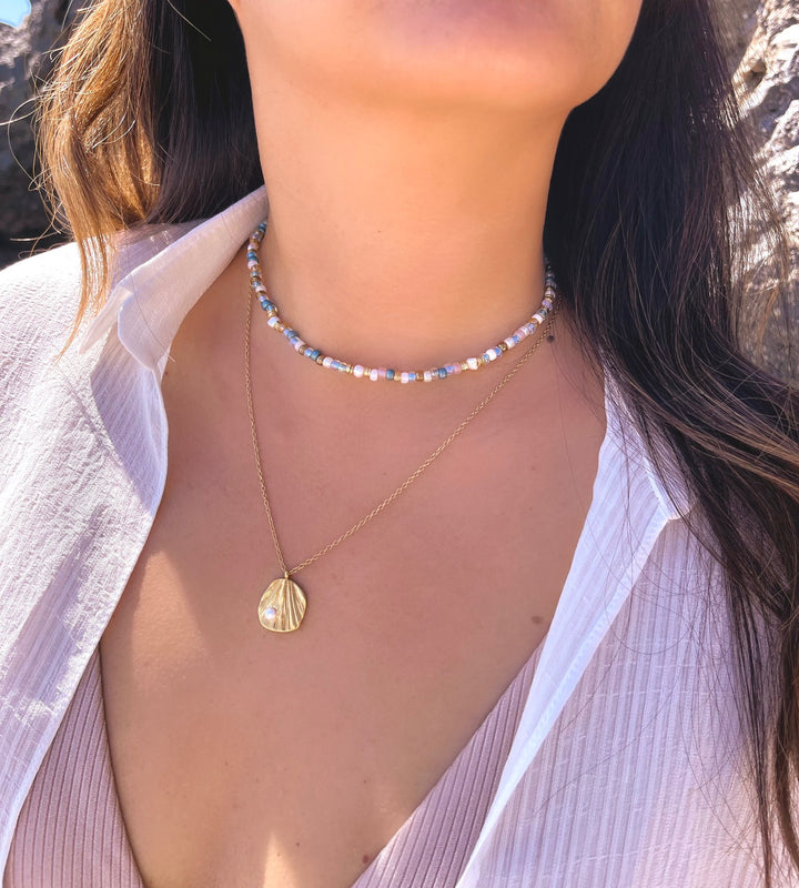 Olivia Le Shimmer Blue beaded necklace on model showing multi color shimmer beads on a necklace layered with another necklace