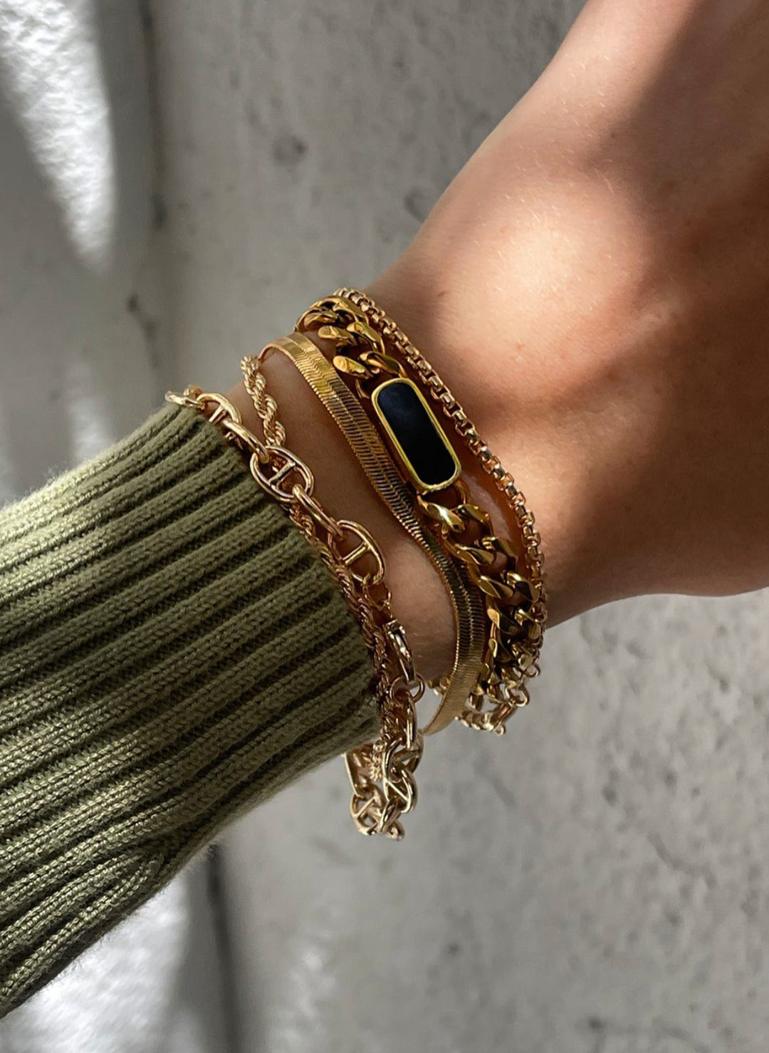 Olivia le tessa gold cuban chain bracelet shown on model with layered bracelets 