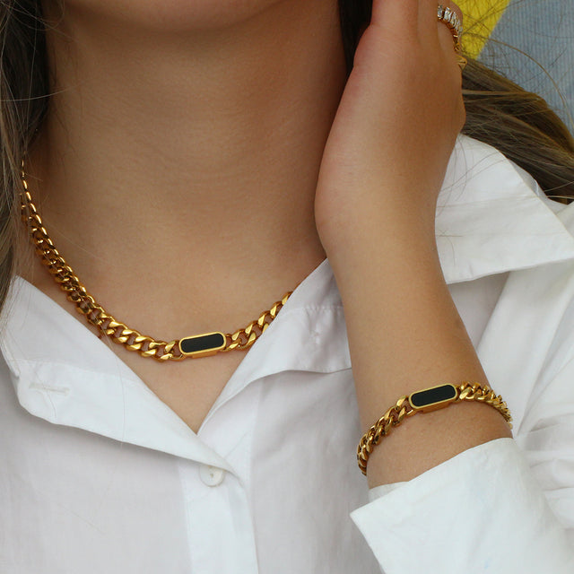 Olivia le tessa necklace shown on model wearing gold cuban chain with black onyx link 