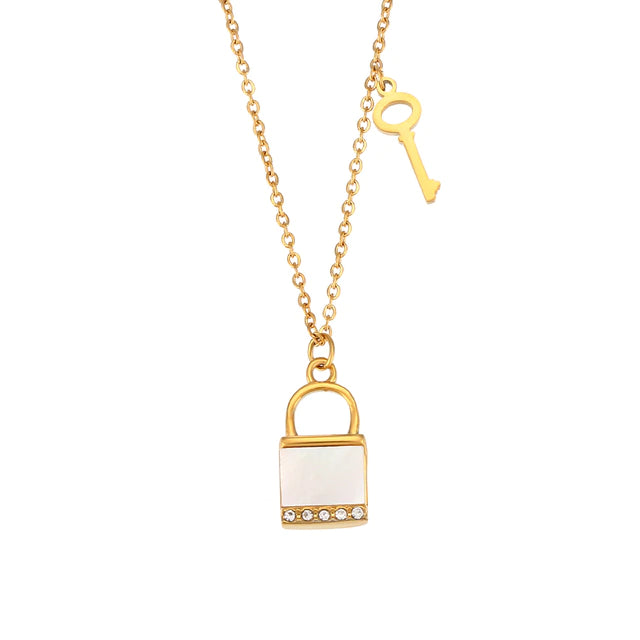 thin gold chain shown with a small padlock pendant charm adorned with a mother of pearl shell accent and small key 