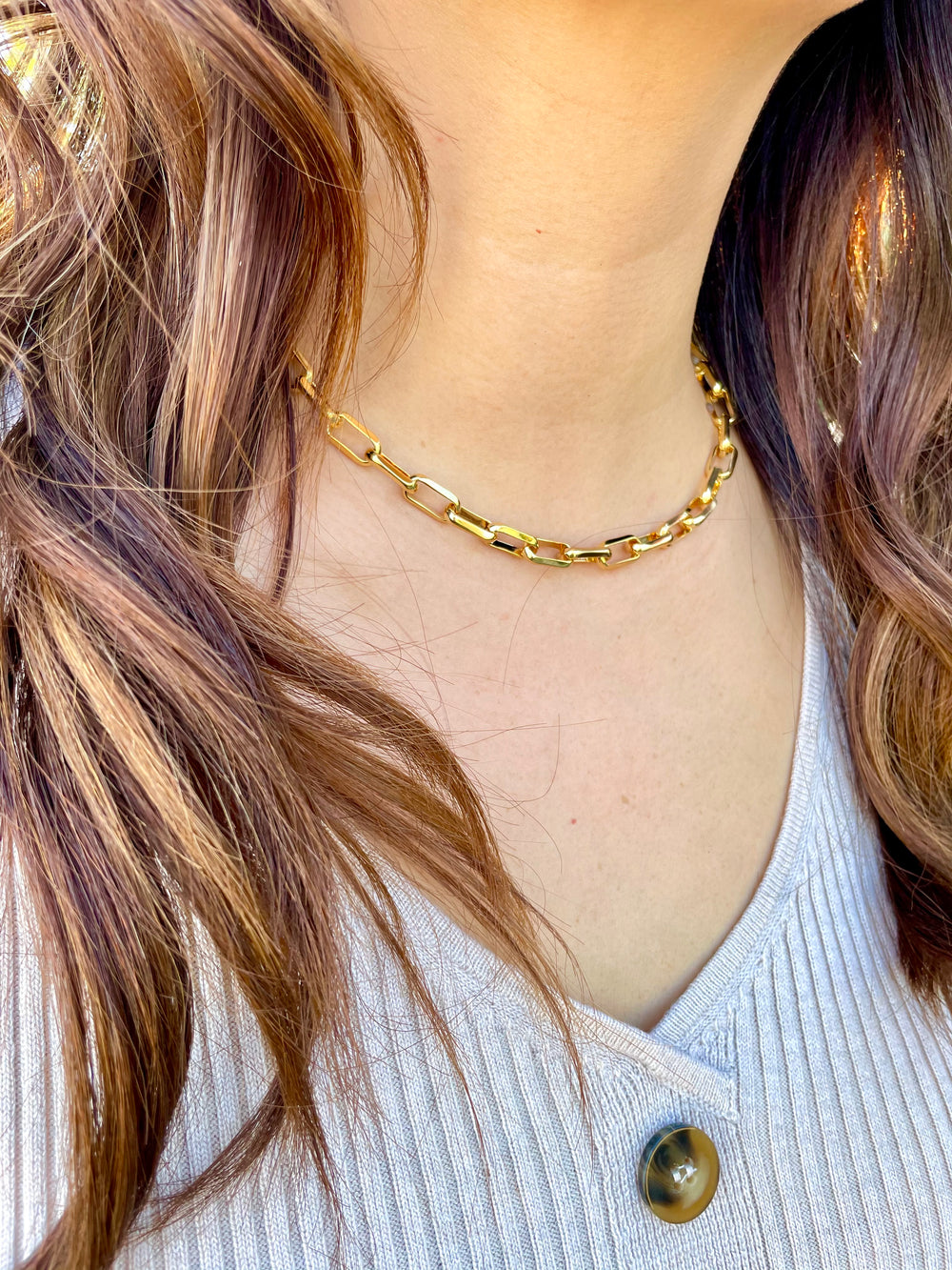olivia le model wearing linked up necklace chain with a v neck sweater dress showcasing the rectangular links on the chain