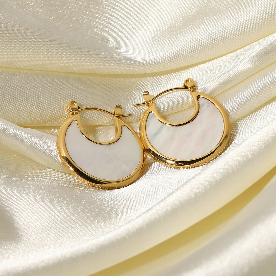 olivia le tessa hoop earrings shown displayed on shiny silk fabric