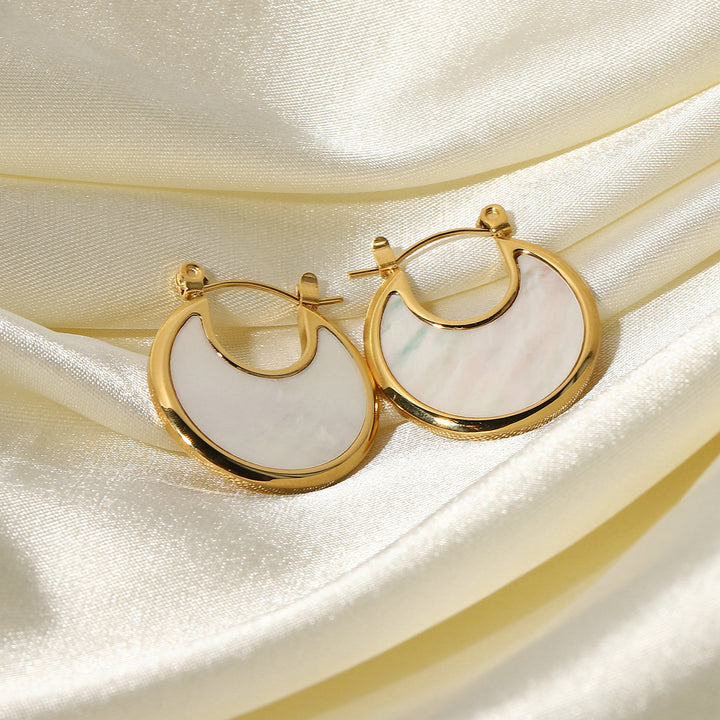 olivia le tessa hoop earrings shown displayed on shiny silk fabric