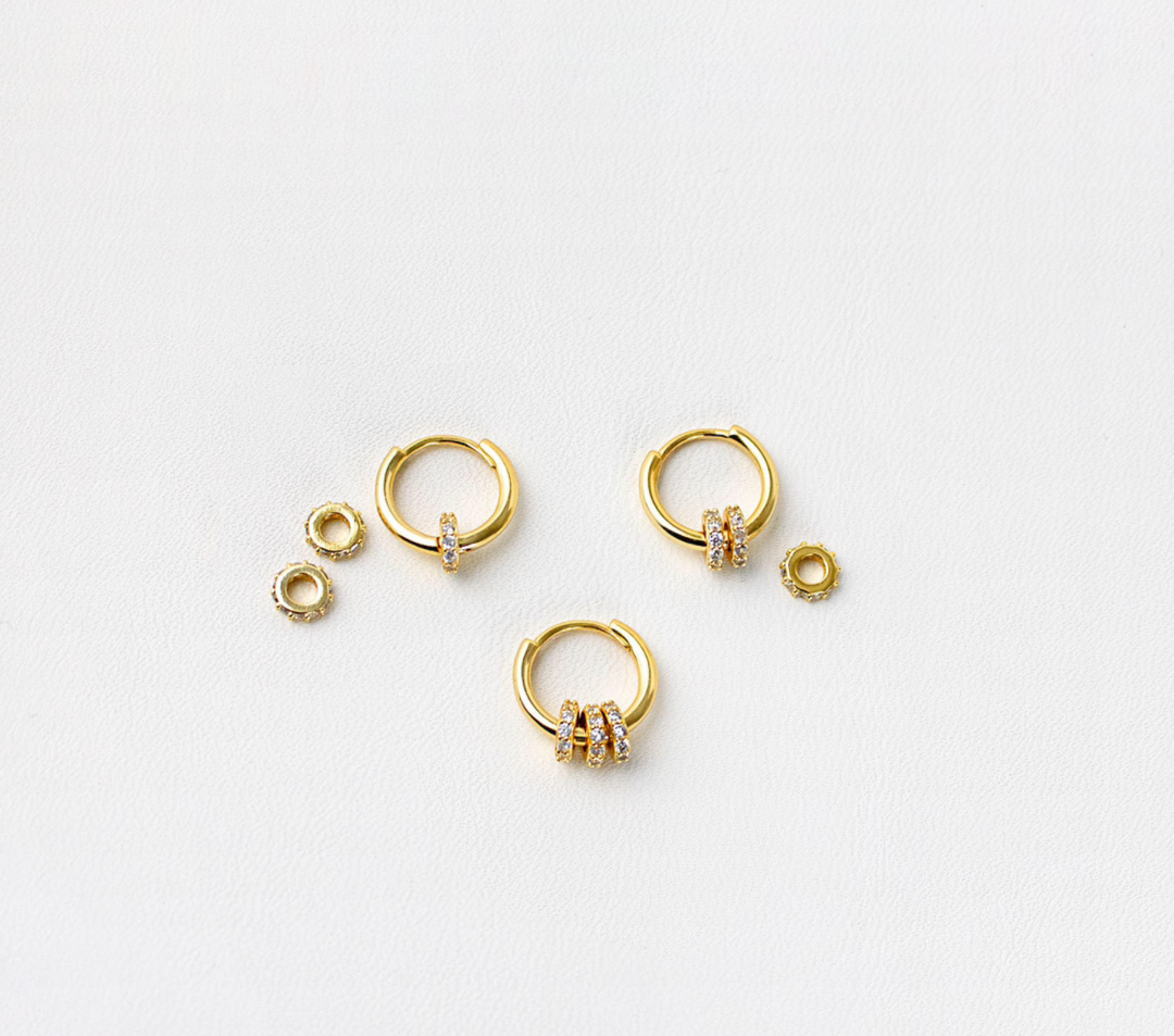 olivia le emma hoop earrings shown laid flat with options of removed charms shown with one two or three charms atttached