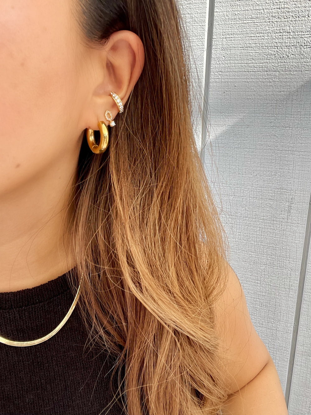 olivia le madison opal studs on models ear shown with hoops and pave ear cuff . madison opal earrings are gold with a opal stone